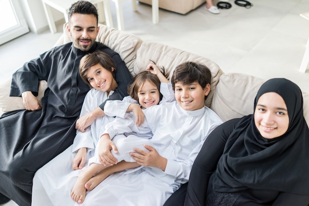 Gelukkige Arabische Moslimfamilie bij modern huis die pret en goede tijd hebben samen