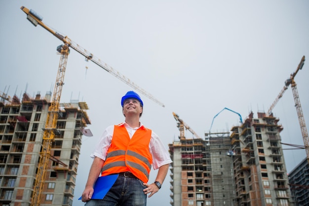 Gelukkige architect op een bouwplaats tijdens een woningbouwproject.