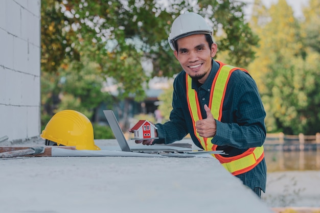 Gelukkige architect werknemer ingenieur bezig met de bouw van zijn laptop site