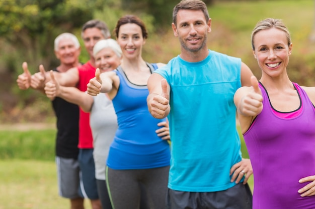 Foto gelukkige atletische groep met duimen omhoog op een zonnige dag