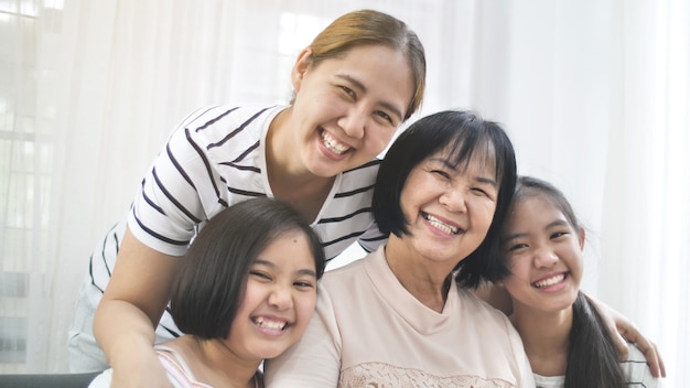 Foto gelukkige aziatische familie die samen thuis, multigeneratie van wijfje glimlachen