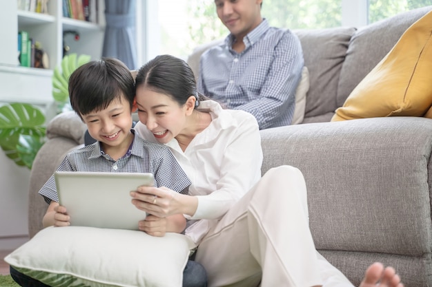 Foto gelukkige aziatische familie het besteden tijd samen aan bank in woonkamer.