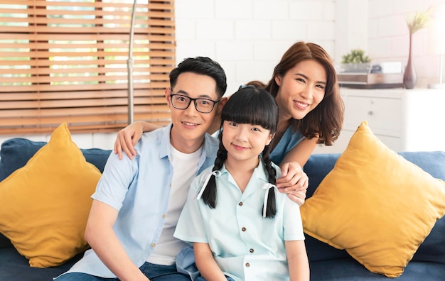 Gelukkige Aziatische familie knuffelen en maken samen een foto op de bank thuis in de woonkamer