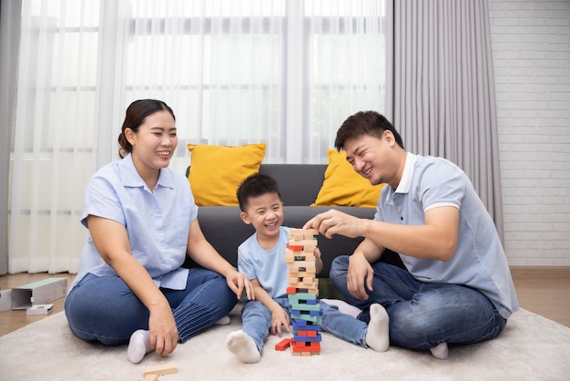 Gelukkige Aziatische familie spelen met houten bakstenen in de woonkamer, Lifestyle ontspannen thuis concept