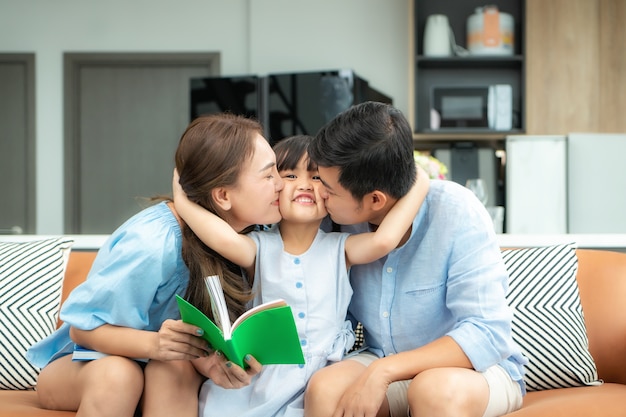 Gelukkige aziatische familie thuis lezen