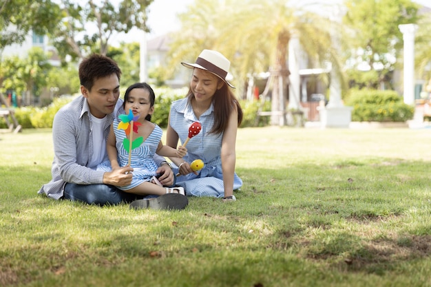 Gelukkige aziatische familie. vader, moeder en dochter in een park bij natuurlijk zonlicht. familie vakantie concept.