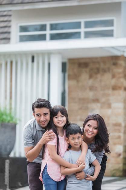 Gelukkige aziatische familie voor hun huis