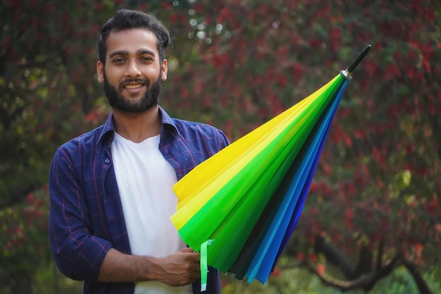 Gelukkige aziatische jongen met kleurrijke paraplu in de zomer buiten