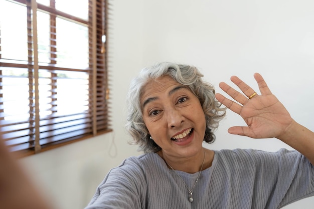 Gelukkige Aziatische Ouderen die selfie-foto's maken met een smartphone samen in huis Portret Senior mensen glimlachen en kijken naar de camera