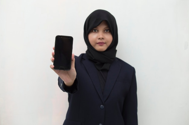 Gelukkige Aziatische vrouw in hijab die mobiele celtelefoon demonstreren Portret van glimlachend meisje