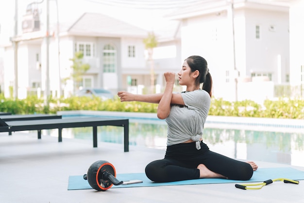 Gelukkige Aziatische vrouw stretching oefening en yoga workout in de ochtend thuis