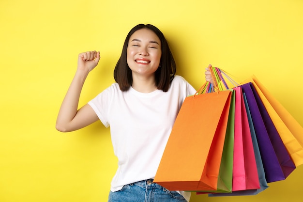 Gelukkige Aziatische vrouw tevreden na het winkelen in de uitverkoop