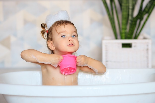 Gelukkige baby baadt in de badkamer