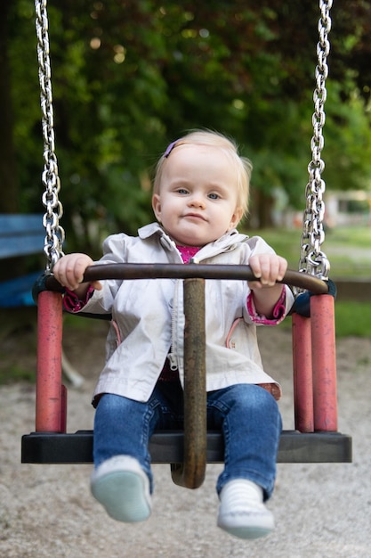 Gelukkige baby die met de schommel speelt