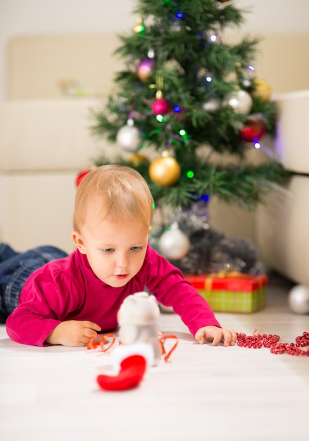 Gelukkige baby in de buurt van de kerstboom