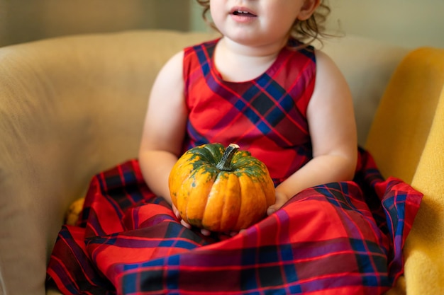 Foto gelukkige baby met een pompoen voor halloween thuis