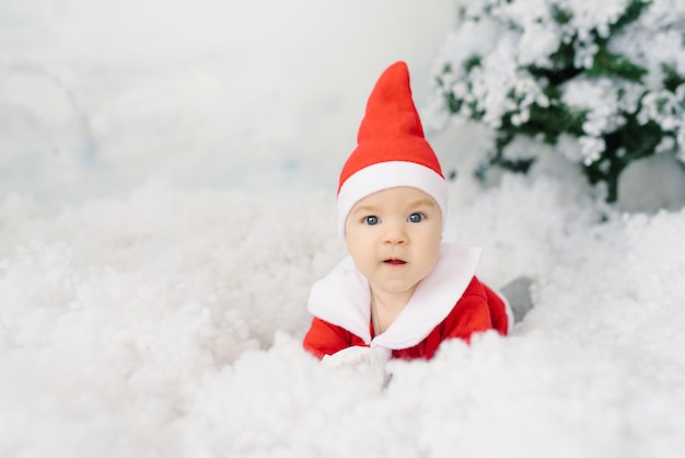 Gelukkige babykerstman met blauwe grote ogen. Plaats om te kopiëren. Kerstkortingen, verkoop, gelukkige jeugd