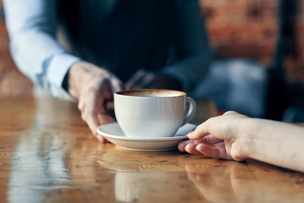 Gelukkige barman serveert een kop koffie aan een patiënt in een café drink bakstenen muur interieur hoge kwaliteit foto