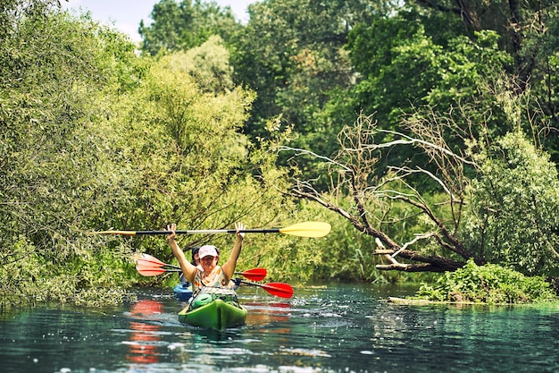 Gelukkige beste vrienden die plezier hebben op een kajak. Kajakken op de rivier.