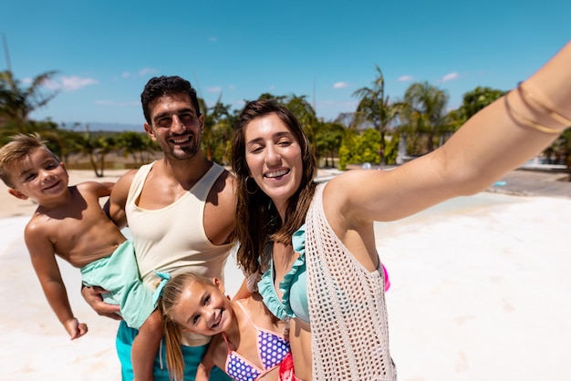 Gelukkige biraciale familie die selfie neemt op het strand. Kwaliteitstijd, levensstijl, familie, zomer en vakantieconcept doorbrengen.