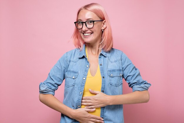 Foto gelukkige blanke vrouw die geen problemen heeft met de spijsvertering, hand in hand op de buik