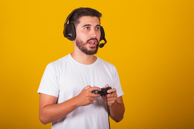 Gelukkige Braziliaanse Latijns-Amerikaanse man met headset en videogamecontroller aan het spelen