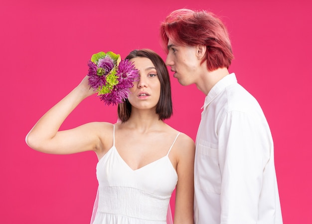 Gelukkige bruidspaar bruidegom en bruid in trouwjurk met bloemen samen plezier