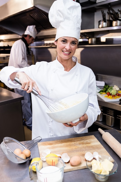 Gelukkige chef-kok die kom eieren zwaaien