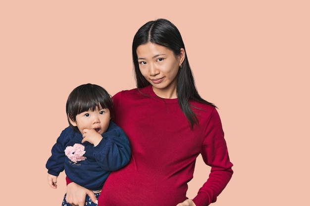 Gelukkige Chinese moeder die haar kind knuffelt