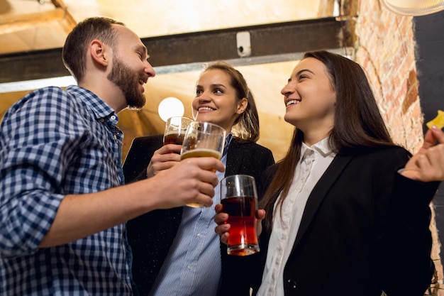 Gelukkige collega's die een bedrijfsevenement vieren na een gespannen werkdag zien er verrukt uit