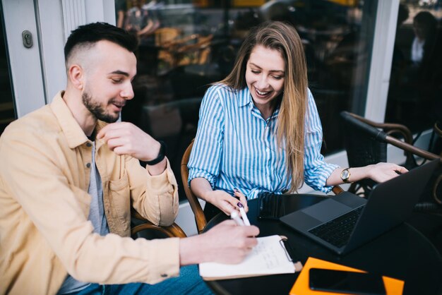 Gelukkige collega's die plezier hebben tijdens het werken in een straatcafé