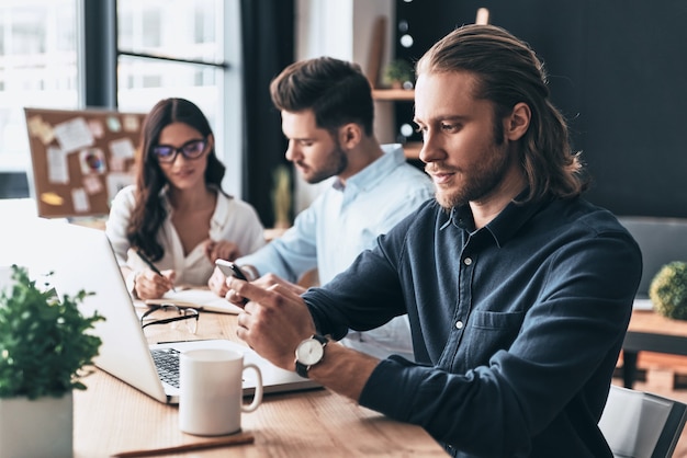 Gelukkige collega's. Jonge moderne collega's in slimme vrijetijdskleding aan het werk