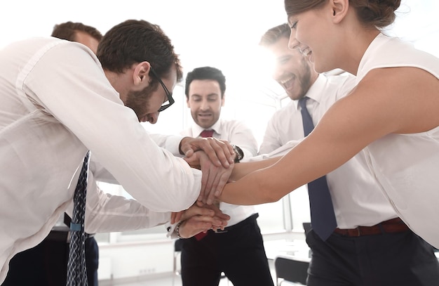 Foto gelukkige collega's verbinden hun handen samen het concept van teamwork