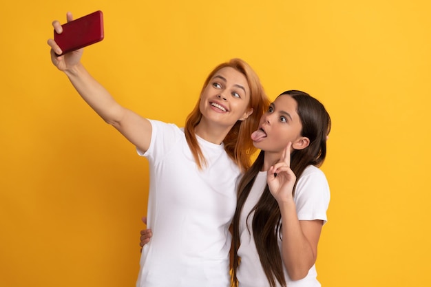 Gelukkige coole moeder en kind maken selfie op telefoon, maker van inhoud.