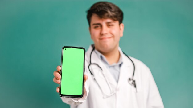 Foto gelukkige dokter met een mobiele telefoon met een groen scherm