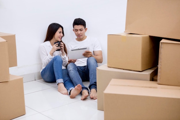 Gelukkige echtpaar rust tijdens het verhuizen naar een nieuw huis