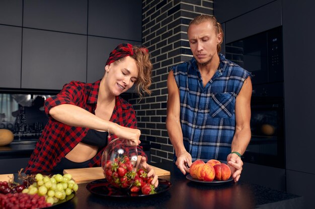 Foto gelukkige echtpaar staat in de keuken thuis en bereidt samen een heerlijk diner voor op de eerste afspraakje van echtgenoten