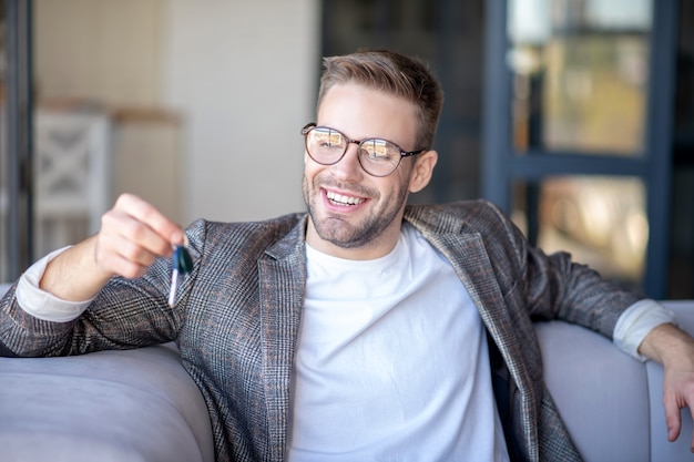 Gelukkige eigenaar. Een vrolijke man met sleutels van een nieuwe auto