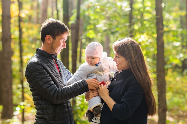 Gelukkige en jonge familie samen ontspannen in de gouden en kleurrijke herfst natuur.