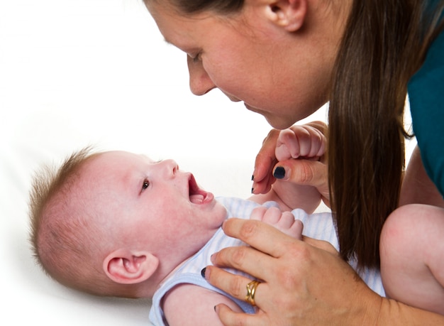 Gelukkige en moeder en baby die spelen lachen.