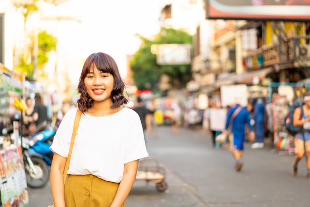 Gelukkige en Mooie Aziatische vrouw die bij Khao Sarn Road, Thailand reizen