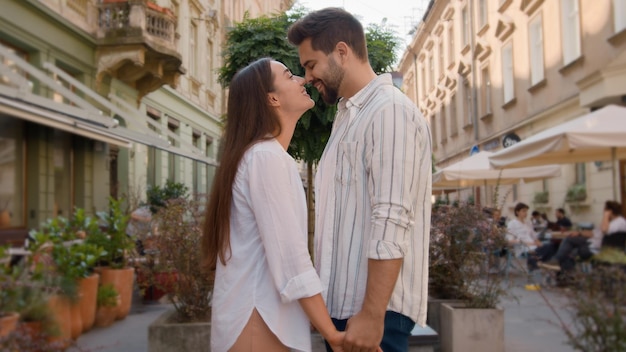 Gelukkige Europese blanke koppel stad straat handen vasthouden kussen samen man vrouw liefhebbers