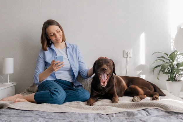 Gelukkige Europese vrouw en haar labrador retriever-hond thuis