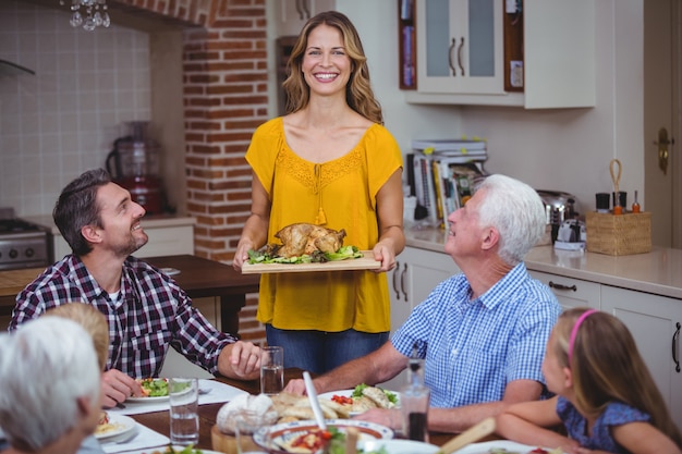 Gelukkige familie aan eettafel met moeder