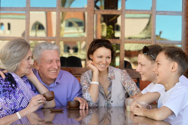 Gelukkige familie aan tafel buiten in de zomer