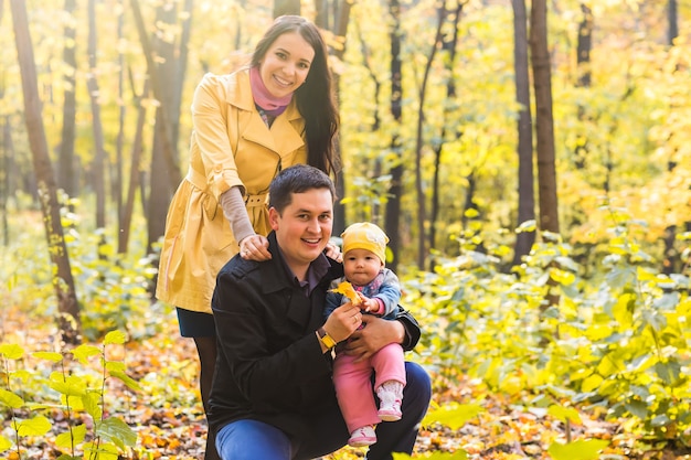 Gelukkige familie buiten in de herfst. Baby en moeder en vader