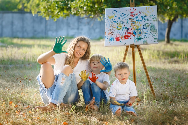 Gelukkige familie buiten tekenen. jonge moeder die pret met haar kleine kinderen heeft