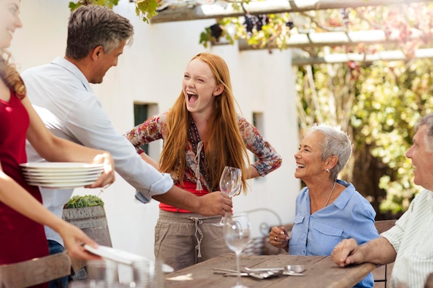 Gelukkige familie dekt tafel buiten voor de lunch