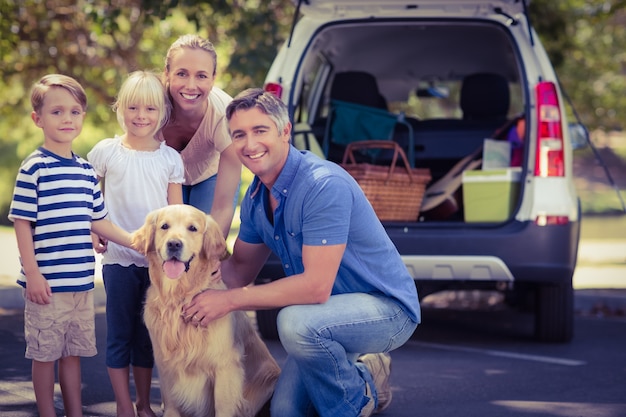 Gelukkige familie die bij de camera met hun hond glimlacht