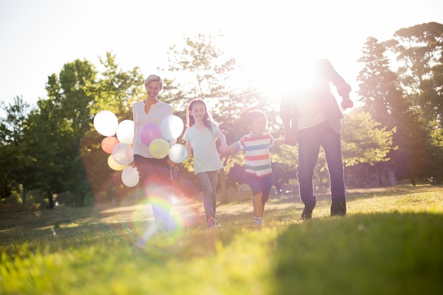 Foto gelukkige familie die bij het park loopt